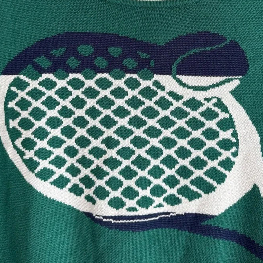 Close-up of the tennis racket graphic on a green knit sweater