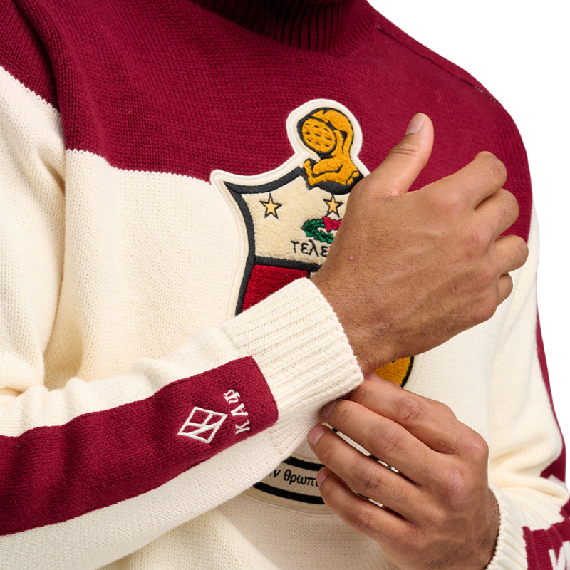 Detailed view of a custom fraternity sweater's chest area, showcasing an embroidered fraternity crest and 'KAP' on the sleeve.