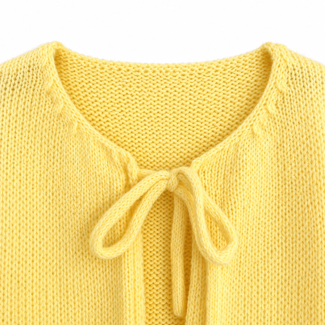 Close-up of V-neckline and tie detail on a yellow knit cardigan