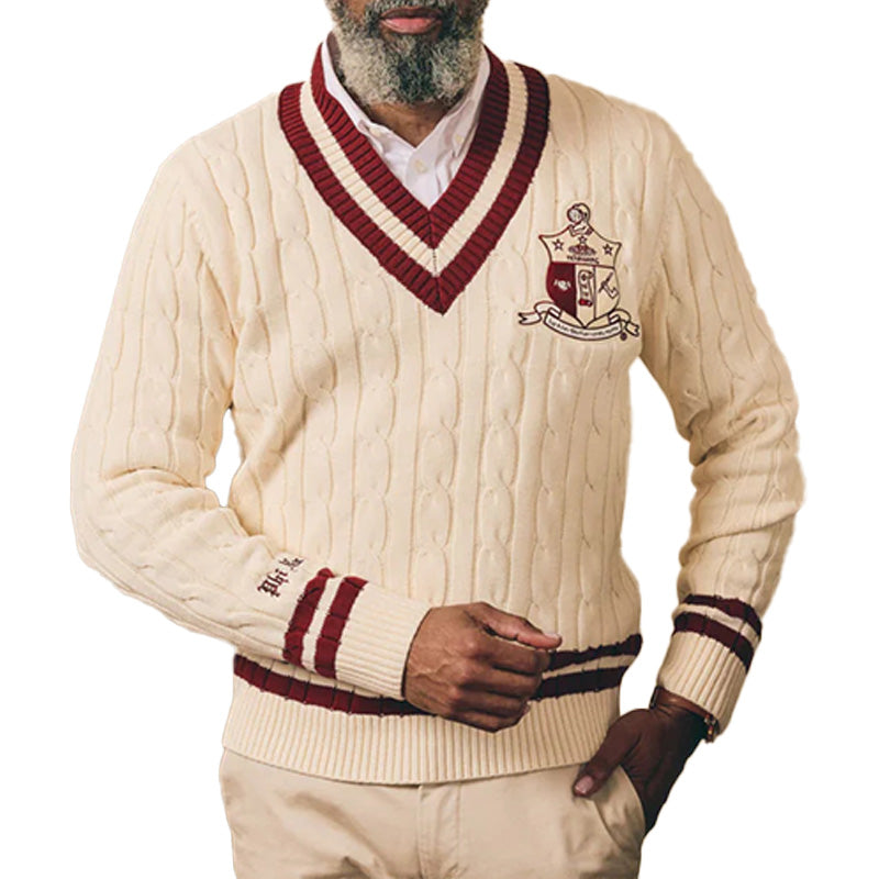 Man wearing cream cable knit sweater with maroon trim and “Kappa Alpha Psi" Logo embroidery