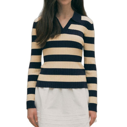 Woman wearing a custom wool striped polo sweater in navy and beige, featuring a V-neck and fitted silhouette.