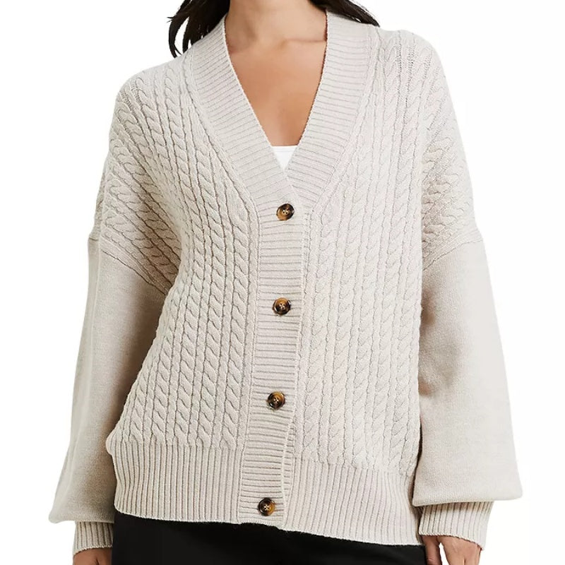 Woman wearing a custom wool v-neck cardigan with a button-down front and cable-knit patterns, front view.