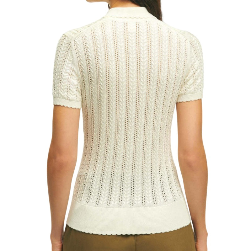 Rear view of a woman wearing a custom cream linen knit polo sweater showcasing detailed vertical lace patterns.