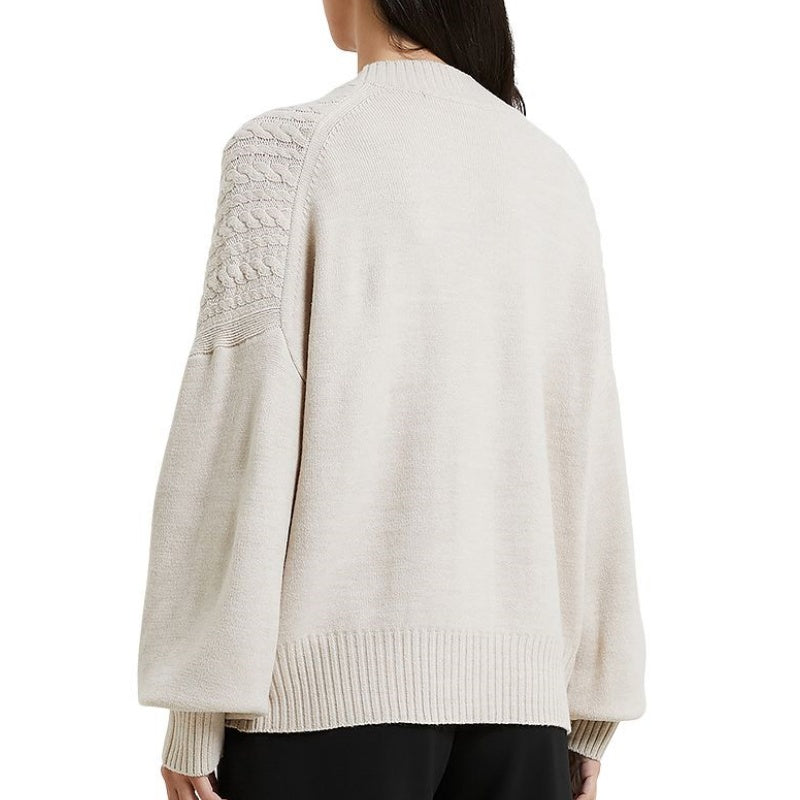 Back view of a woman wearing a custom wool v-neck cardigan, showcasing the intricate knit details on the shoulders and sleeves.