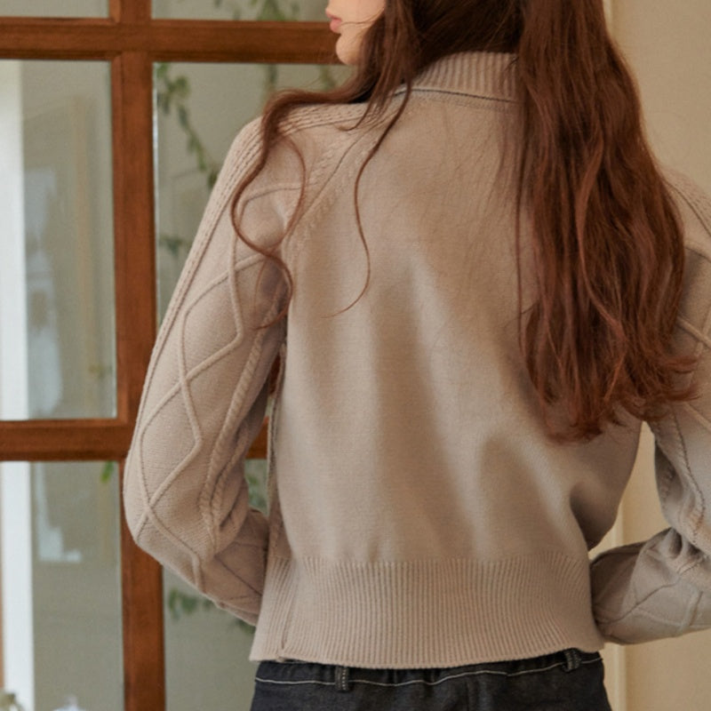 Back view of a woman wearing a custom cashmere zipper sweater, showcasing the detailed cable-knit patterns on the sleeves and back.