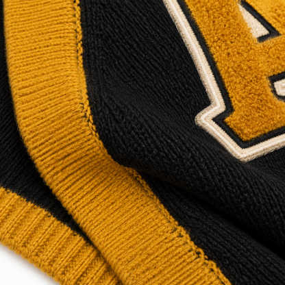 Knit texture and chenille letter embroidery close-up 