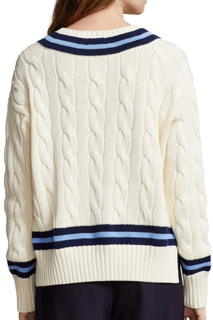 Rear view of a cabled cotton V-neck sweater showcasing the detailed knit pattern and contrasting navy-blue striped design on the waistband