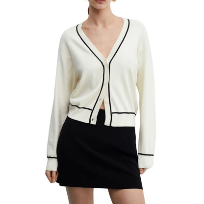 Close-up of the modeled front view, showcasing the fit, black contrast trim, and button-up design of the white knit cardigan.