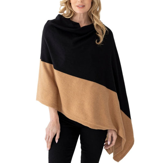 A person wearing a custom 100% acrylic knit sweater poncho with a black and camel color-blocking design.
