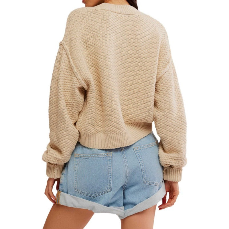 Back view of the knit texture and design of a beige cardigan, emphasizing its relaxed fit and quality craftsmanship.