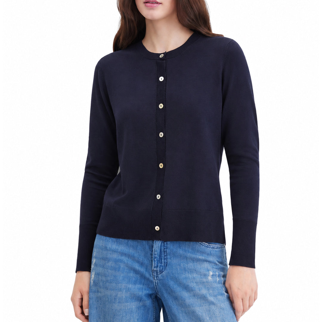 Woman wearing a black button-front knit cardigan with blue jeans.