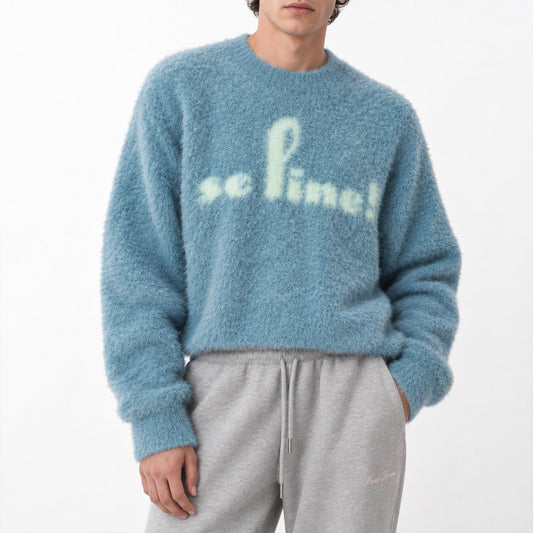 Blue knit pullover with cream script lettering, front view.