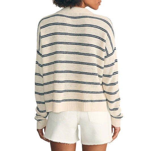 Back view of a woman in a custom wholesale cotton blend striped V-neck pullover sweater in beige and white shorts