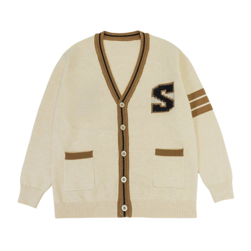 A cream-colored V-neck varsity cardigan with brown trim and buttons, featuring a large "S" on the left chest and two brown stripes on the right sleeve.
