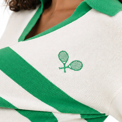 Close-up of the green V-neck trim and chest emblem on a white striped knit cardigan
