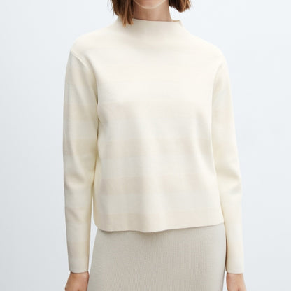 Front view of a woman wearing a white long-sleeve sweater with a subtle striped pattern, paired with a matching skirt.
