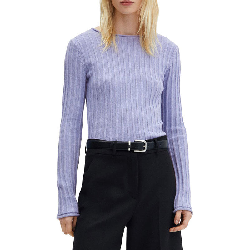 Front view of a woman wearing a light purple wool blend ribbed knit sweater, styled with black trousers and a sleek belt.