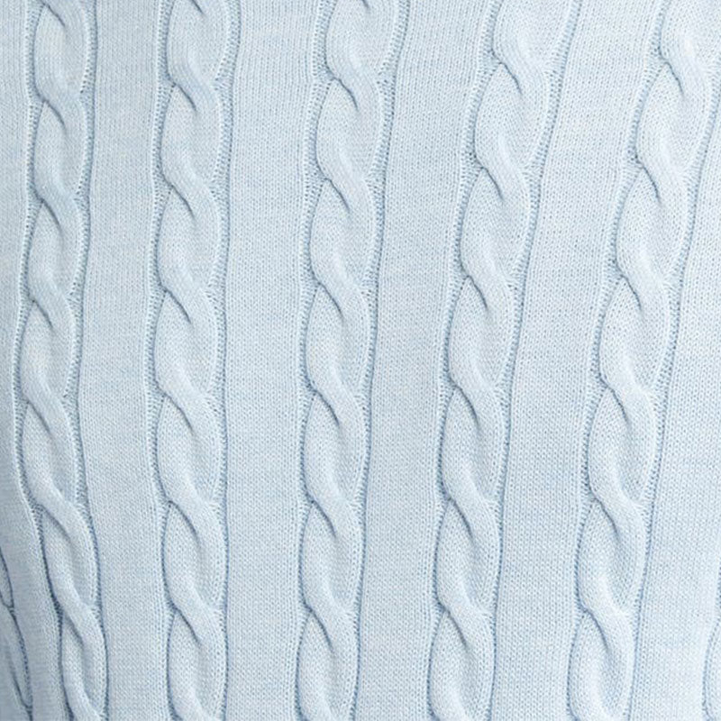 Close-up image of the light blue cable knit pattern, highlighting the intricate texture of the sweater fabric.