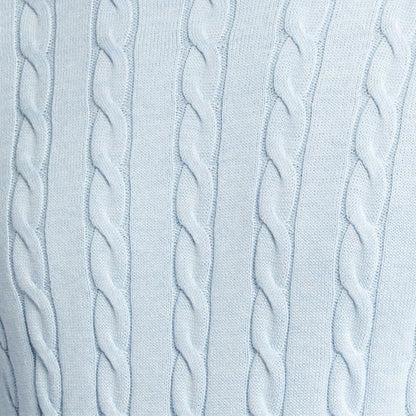 Close-up image of the light blue cable knit pattern, highlighting the intricate texture of the sweater fabric.