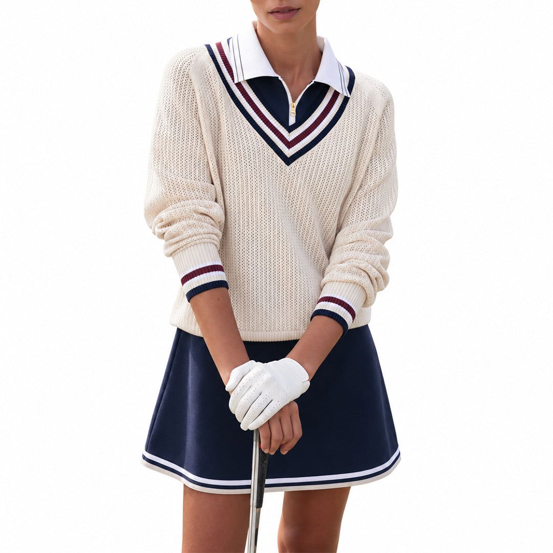 Woman wearing a cream varsity V-neck sweater with navy and burgundy stripes