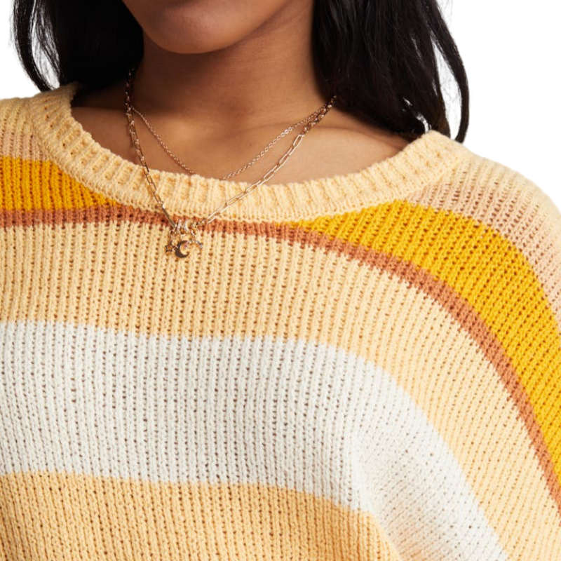 Close-up detail of the custom striped knit sweater, focusing on the neckline and fabric texture. The sweater features vibrant yellow, white, and orange stripes with a soft cotton blend material.