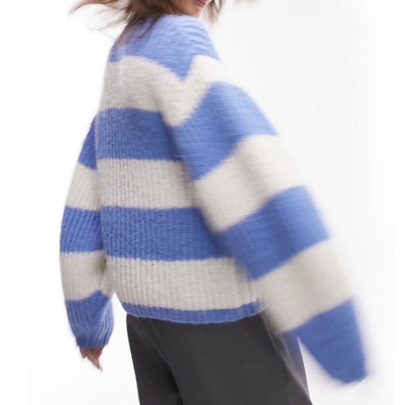 Back view of a woman wearing a custom wool blend ribbed knit sweater with blue and white horizontal stripes, emphasizing the oversized and comfortable fit.