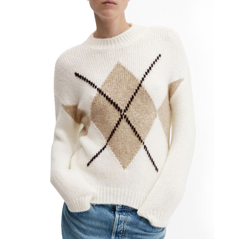 Model wearing a cream-colored sweater with a beige and black argyle pattern. The sweater has a textured knit design, ribbed cuffs, and is paired with blue jeans.