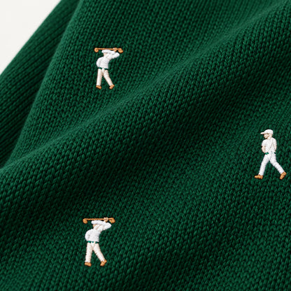 Close-up of embroidered golfer motifs on dark green textured knitwear