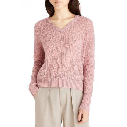 Model wearing a pink custom wool blend cable knit sweater with a V-neck, front view.