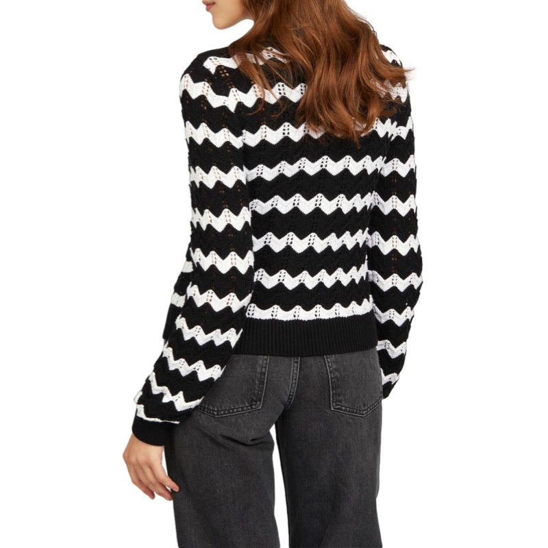 Back view of a custom black and white zigzag stripes knit cardigan, highlighting the consistent zigzag pattern and the comfortable fit on the model.