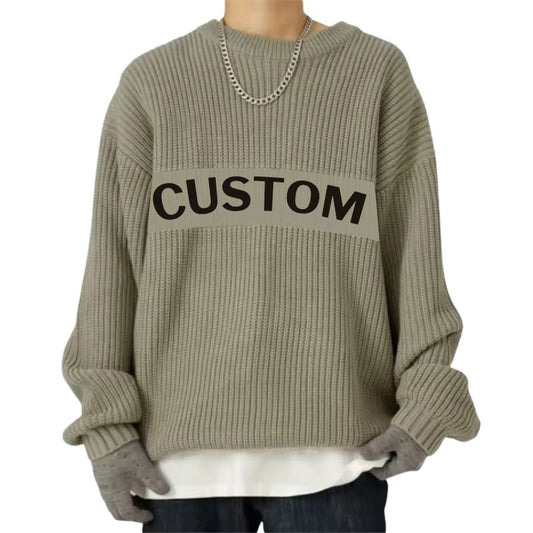 Person wearing a grey oversized ribbed knit sweater with a custom logo printed across the chest, accessorized with a chain necklace.