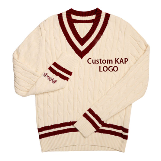 Cream cable knit sweater with maroon trim and "Custom KAP LOGO" embroidery