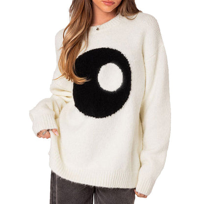 Slightly angled front view of a woman in a white knit sweater displaying the yin-yang pattern and ribbed cuffs.