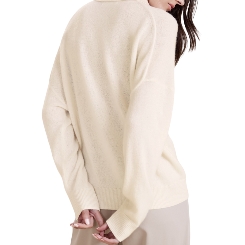 Back view of a woman wearing a beige cashmere blend knit sweater with a polo collar and ribbed cuffs and hem.