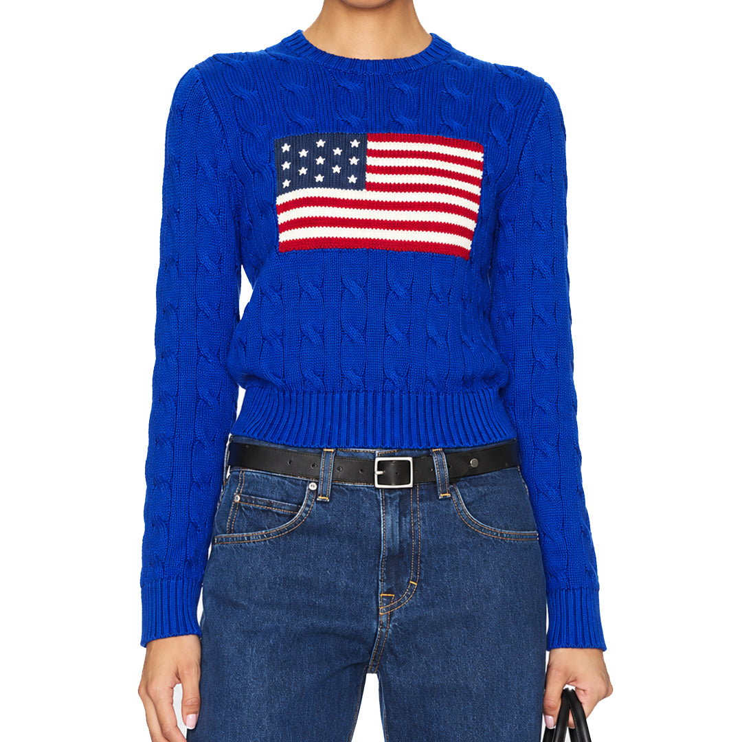 Model wearing a blue American flag knit pullover with jeans