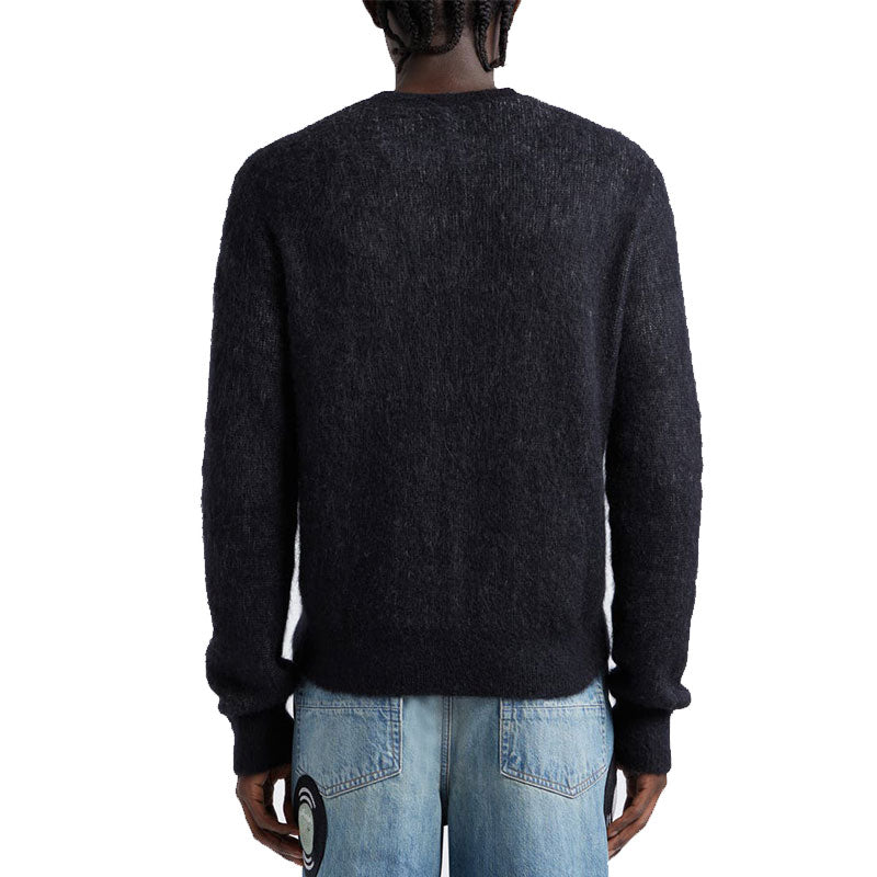 Back view of a custom mohair sweater, showcasing the fine texture and quality of the knit fabric, worn by a model with braided hair.