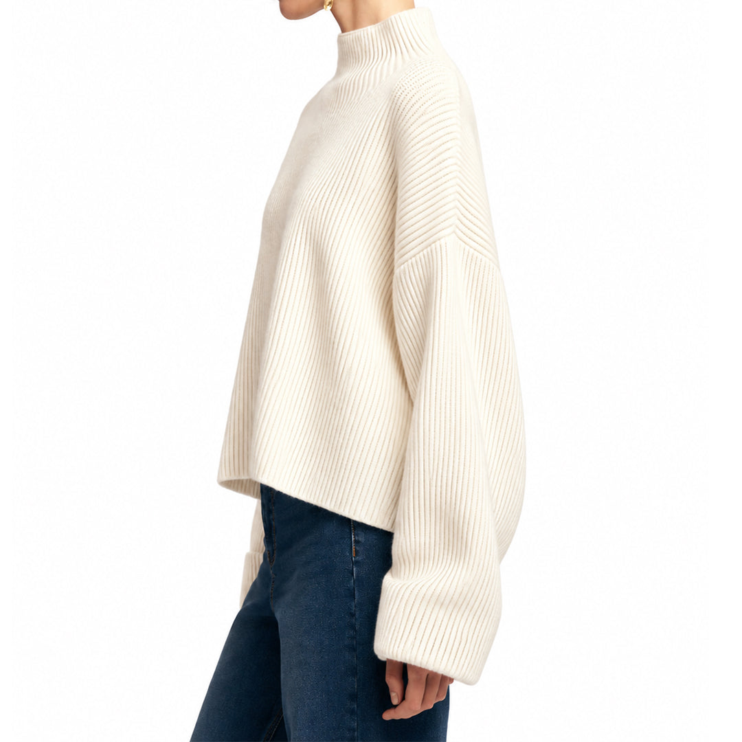 Rear view showing the loose silhouette of an ivory knit pullover.