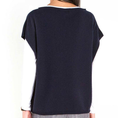 Back view of a woman wearing a custom crew neck 100% wool knitted sweater in navy blue over a long-sleeve white top.