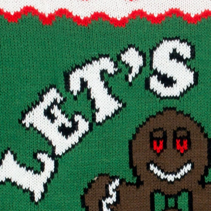 Close-up of a custom Christmas sweater showcasing the text 'Let’s Get Baked' and a gingerbread man design in vibrant green, white, and red colors.