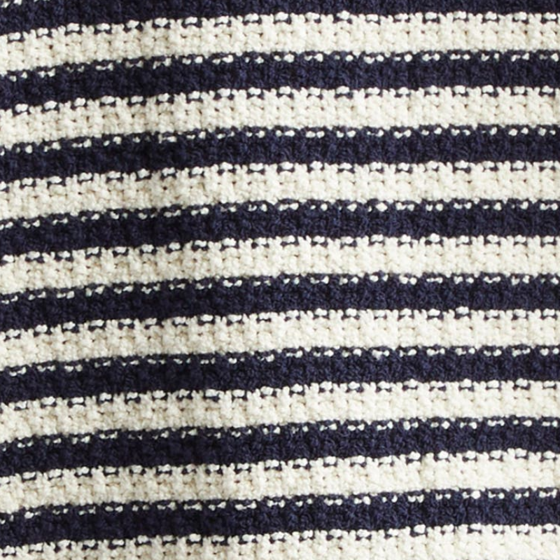 Close-up view of a navy blue and cream striped knit fabric texture.