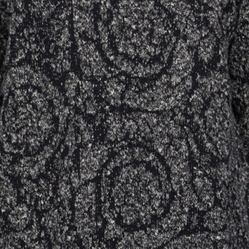 Close-up view of black and gray jacquard knit fabric with intricate floral pattern, showcasing texture and detail.