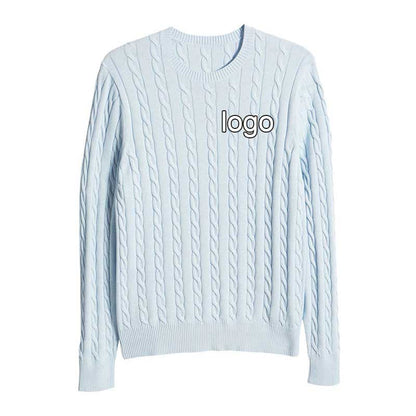 Front view of a light blue cable knit sweater with a custom logo on the chest, displayed on a flat surface.