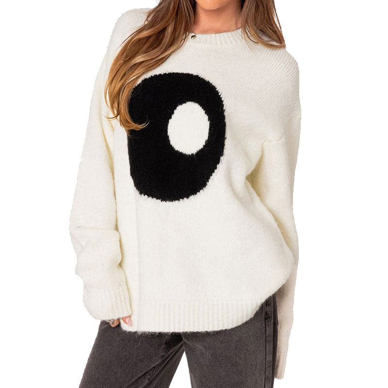 Front view of a woman wearing a white wool blend knit pullover sweater with a black and white yin-yang pattern.