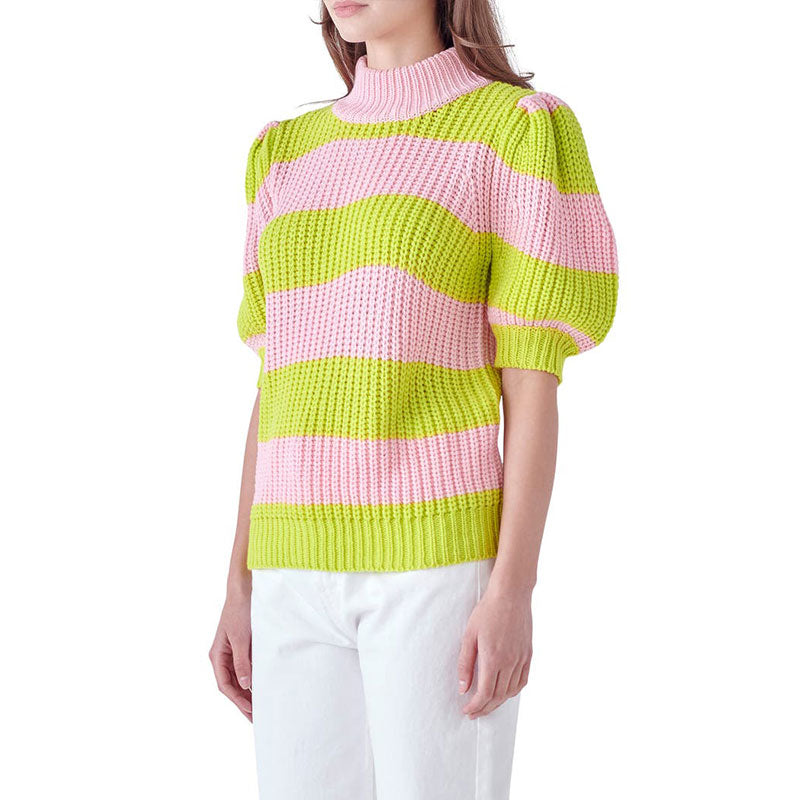 Side view of a model wearing a custom colorful striped two-tone knitwear top in pink and green, showing the puff sleeves and high collar.