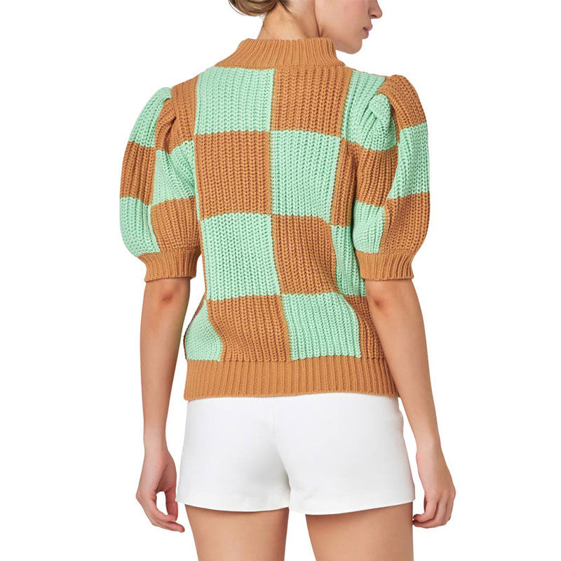 Back view of a woman in a checkerboard knit sweater highlighting the intricate design and comfortable fit.