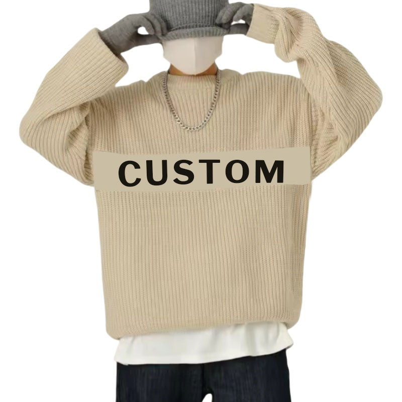 Person wearing a beige oversized ribbed knit sweater with a custom logo printed across the chest, accessorized with a chain necklace and gloves, pulling down a grey beanie.