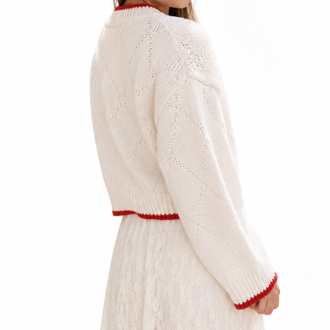 Side view of cream long sleeve pullover with red cuff trim