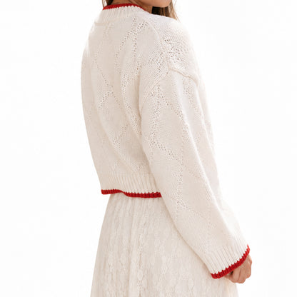 Side view of cream long sleeve pullover with red cuff trim