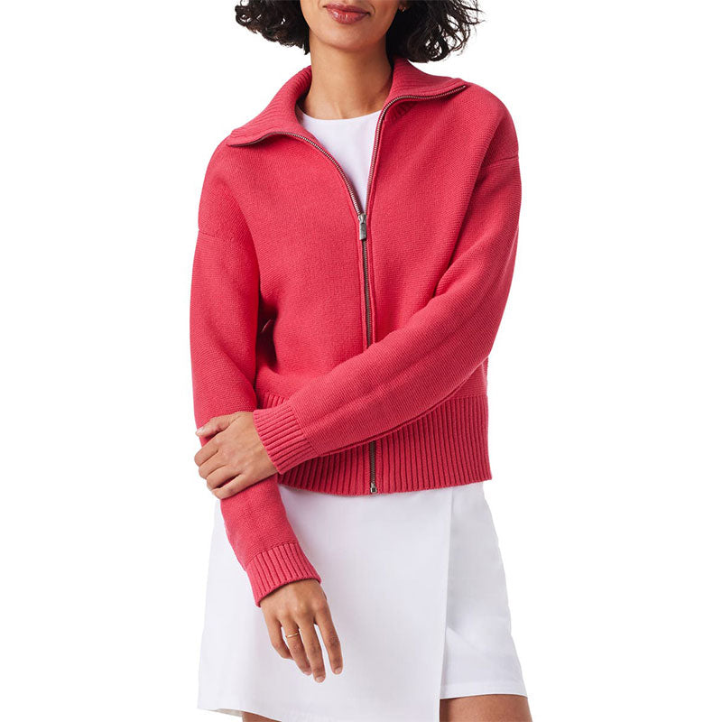 Front view of a custom 100% cotton zip-up knit cardigan in pink, featuring a high collar and a minimalist design, worn by a model over a white dress.