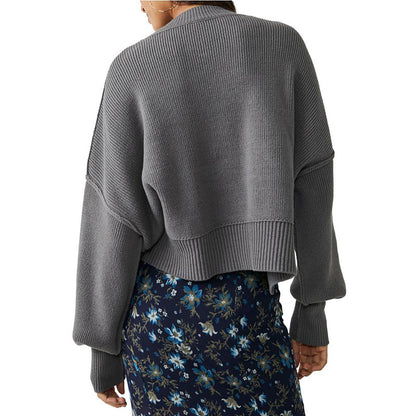 Back view of a woman in a custom wholesale cotton blend solid crew neck knit pullover sweater in grey with a floral skirt